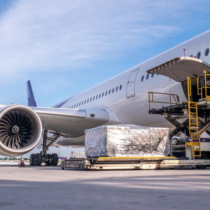 Air cargo logistic containers are loading to an airplane. Air transport shipment prepare for loading to modern freighter jet aircraft at the airport.